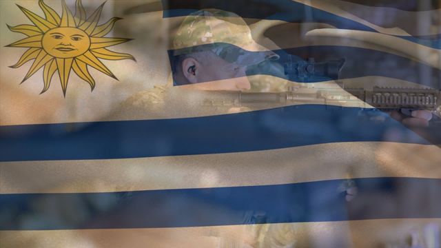 Video shows Uruguay flag with overlay of soldier holding weapon, portraying themes of national pride, military, and defense. Useful for patriotic publications, military defense content, and discussions about public security in Uruguay.