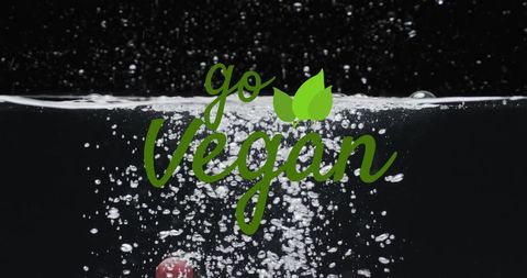 Go vegan text with splashing fruits in water background