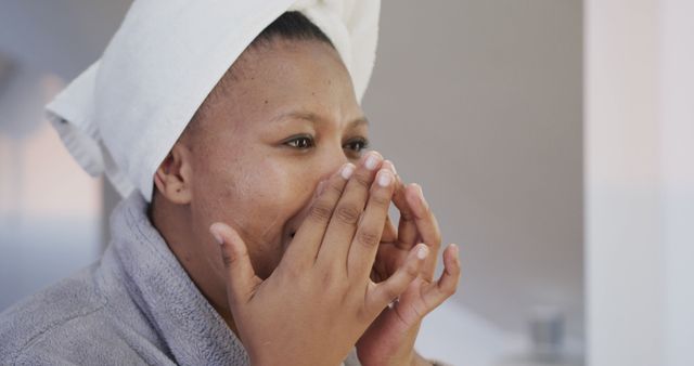 African Woman Applying Skincare Routine in Bathroom - Download Free Stock Images Pikwizard.com