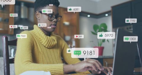 African american woman engaged with digital content on laptop