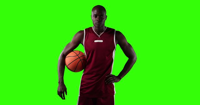 Basketball Player in Maroon Uniform Holding Ball on Green Background - Download Free Stock Images Pikwizard.com