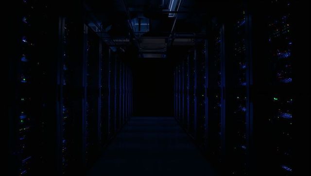 Dark data center aisle with rack servers and blue led lights, dramatic symmetrical perspective