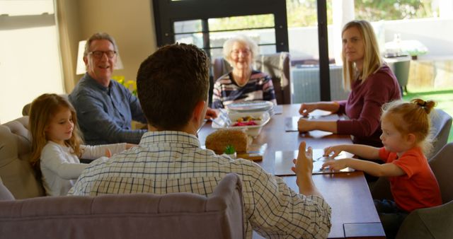 Happy Family Gathering Around Dining Table in Sunlit Home - Download Free Stock Images Pikwizard.com