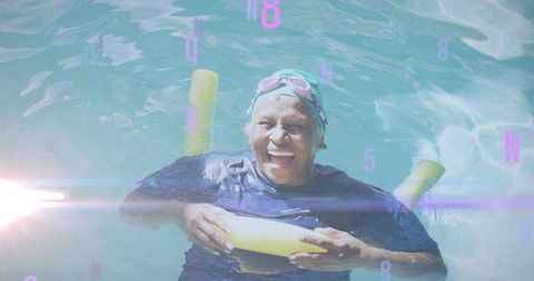 Elderly woman enjoys swimming in pool holding noodle
