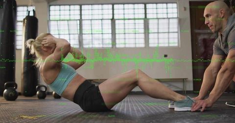 Woman Doing Sit-Ups with Trainer in Modern Gym