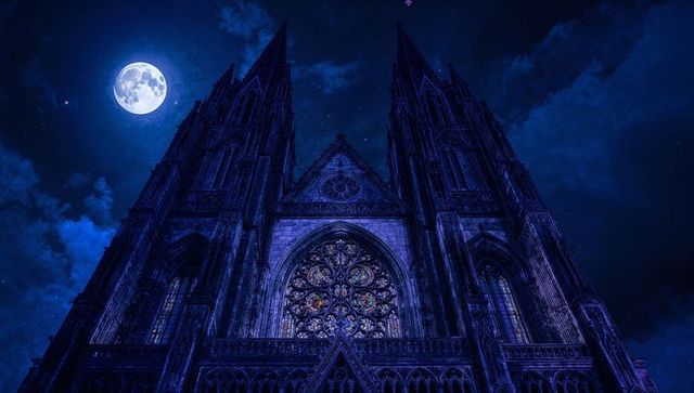 Gothic Cathedral Facade Illuminated by Full Moon Night Sky