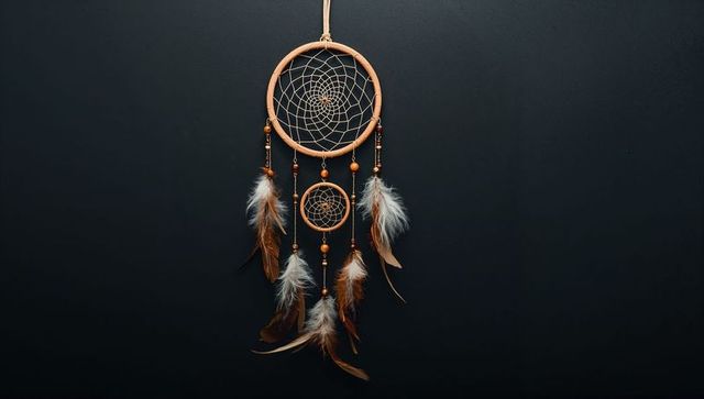 Handmade dreamcatcher with feathers against dark background