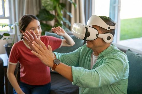 Father and daughter having fun with virtual reality at home