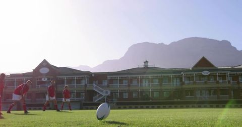 Rugby players preparing penalty kick on school sports field with mountain backdrop
