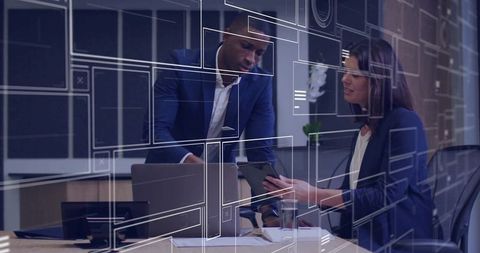 Colleagues collaborating over tablet and laptop with digital HUD overlays in modern office