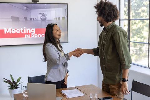 Diverse Colleagues Shaking Hands in Modern Conference Room