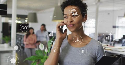 Woman talking on phone holding folder in office with sustainability and analytics overlay