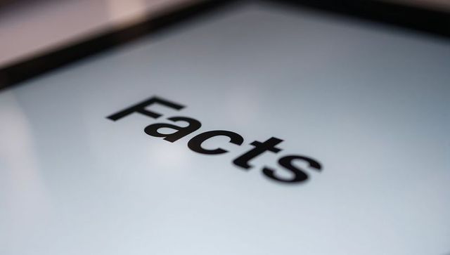 Displaying bold facts text on digital display with minimalist desk reflections and glare