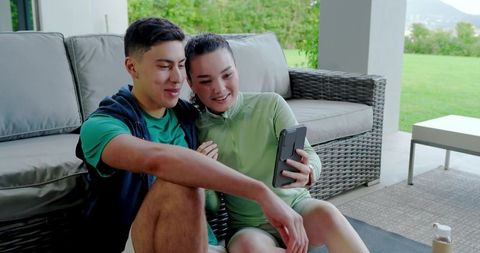 Couple Relaxing on Patio Engaging with Smartphone