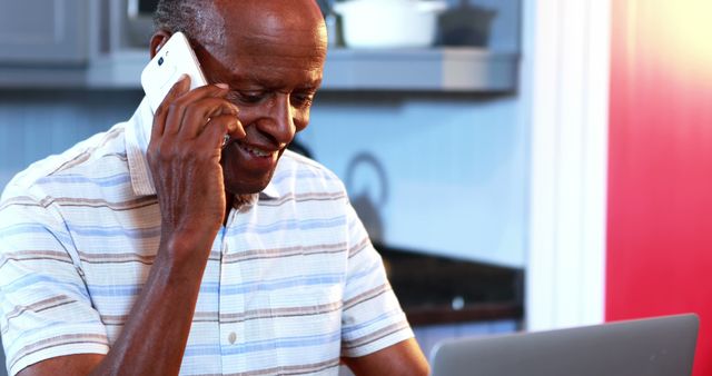 Senior Man Smiling While Talking on Phone and Using Laptop at Home - Download Free Stock Images Pikwizard.com