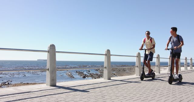 Friends Enjoying Electric Scooter Ride Along Seaside Promenade - Download Free Stock Images Pikwizard.com