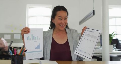 Confident Asian Businesswoman Presenting Business Reports in Modern Office