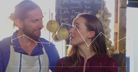 Young market vendors smiling while running artisan produce stall with data graph overlay