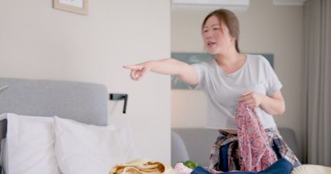 Woman packing clothes at home prior to travel