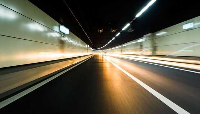 Rushing through urban tunnel with light trails and vanishing point perspective
