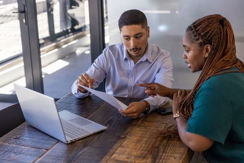 Diverse colleagues reviewing document at modern office desk