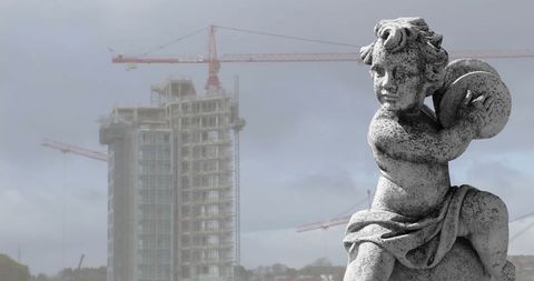 Stone Sculpture Overlooking Urban Construction Site - Download Free Stock Images Pikwizard.com