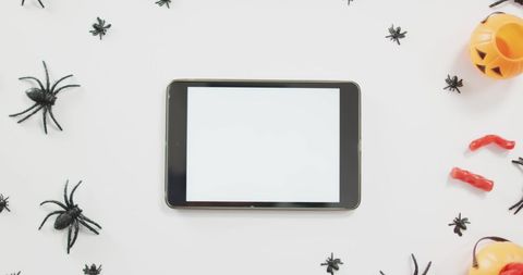 Halloween Decorations and Tablet on White Background