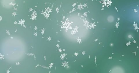 Floating snowflakes over green with soft light glow