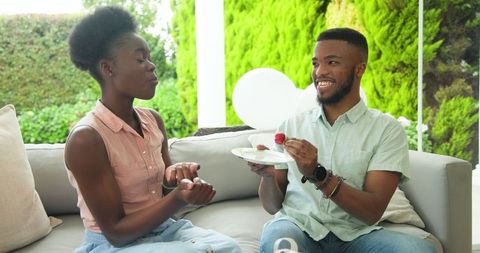 Young Couple Relaxing with Fruit and Gifts on Sunny Patio