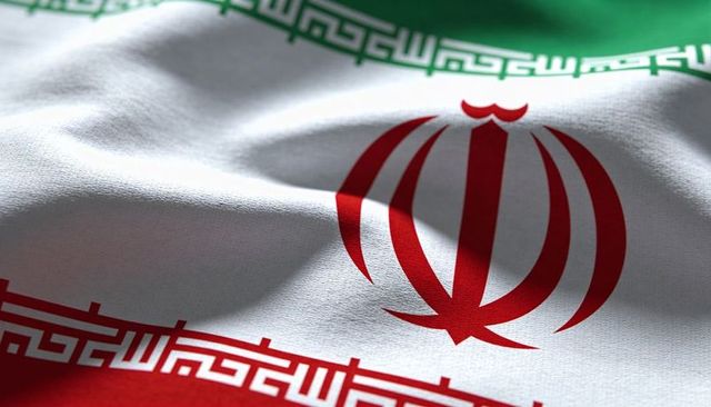 Waving iranian flag closeup showing red emblem, kufic script and woven fabric texture