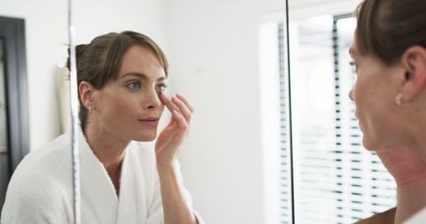 Middle-Aged Woman Checking Skin Routine at Home Mirror - Download Free Stock Images Pikwizard.com