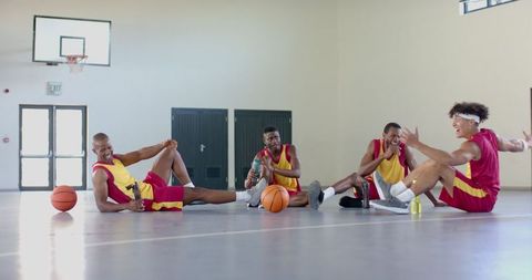 Diverse Basketball Players Relaxing on Indoor Court in School Gym