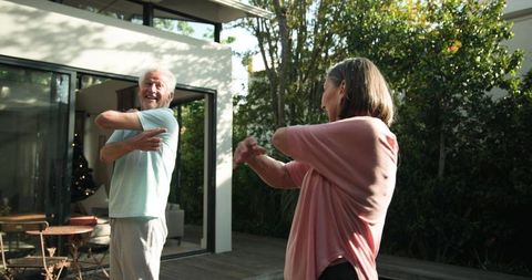 Active senior couple enjoying relaxing shoulder stretches outdoors