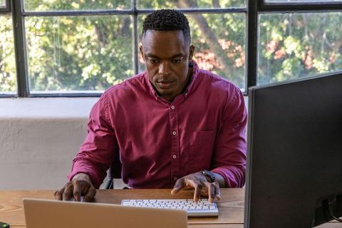 Professional man typing at office workstation in bright workspace
