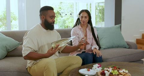 Close Couple Celebrating at Home with Wine and Snacks