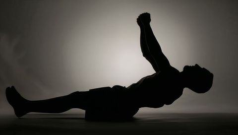 Silhouette Male Performing Core Workout on Mat with Backlight Halo Minimalist Monochrome
