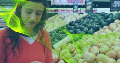 Shopper using phone while selecting produce in supermarket with neon data overlay