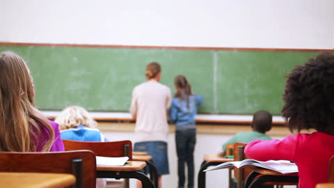 Students Writing on Chalkboard in Classroom Setting
