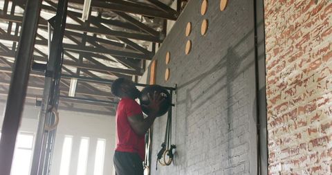 Determined Athlete Using Medicine Ball for Wall Exercises in Gym