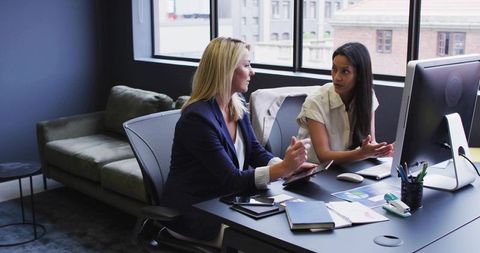 Two Businesswomen Collaborate in Modern Office Environment