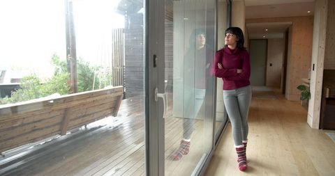 Woman Relaxing by Glass Door Looking Wooden Deck with Swing