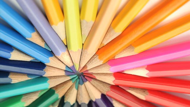 Color pencils are meticulously arranged in a circular design, creating a vivid and eye-catching display. The blend of diverse colors signifies creativity and inspiration, perfect for educational materials, artistic workshops, or office supply advertisements.