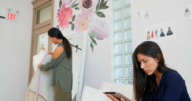 Fashion Designers Working in Studio with Floral Wall Art - Download Free Stock Images Pikwizard.com