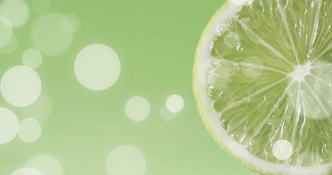 Sliced Lime with Glowing White Bokeh Overlay on Green Background - Download Free Stock Images Pikwizard.com