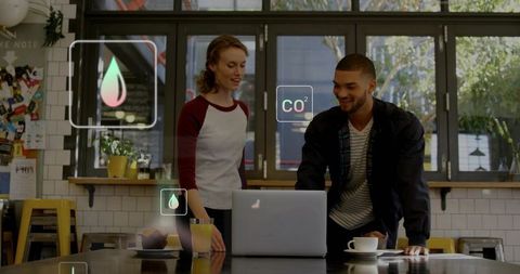 Young professionals collaborating over laptop in trendy cafe with augmented reality overlays