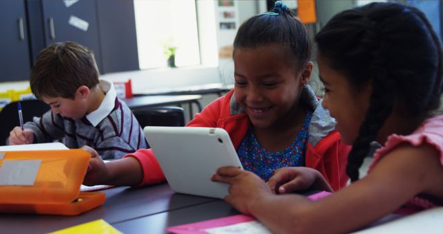 Smiling Schoolchildren Using Tablet Together in Classroom - Download Free Stock Images Pikwizard.com