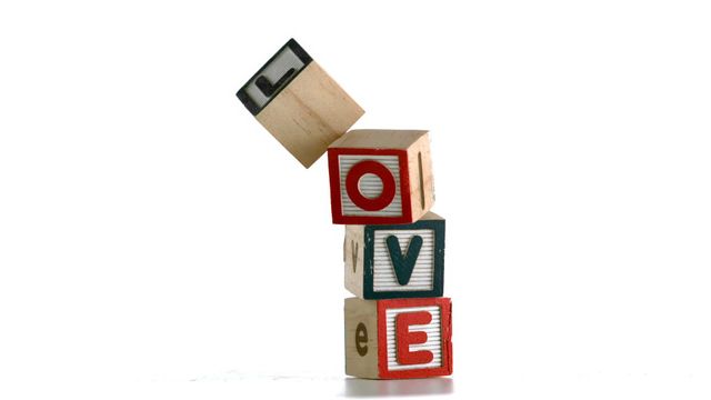 Wooden blocks are stacked to spell the word LOVE in a playful, teetering arrangement. Perfect for illustrating concepts of love in educational projects, playful designs, or graphics needing an element of whimsy. Uses include Valentine's Day promotions, children's book designs, or publicity materials focusing on familial or friendly love.