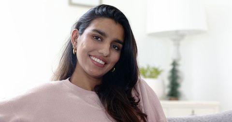 Smiling mid adult woman relaxing in contemporary living room