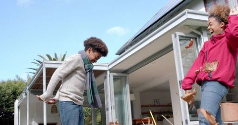 Joyful Mother and Son Celebrating Autumn in Garden