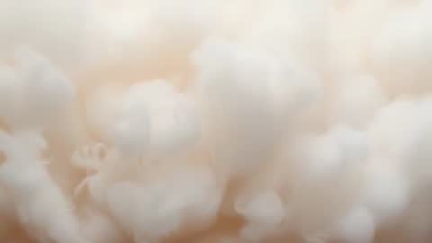 Macro video of cream cotton-like fibers drifting and revealing fine soft texture